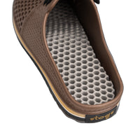 Close-up of a brown sandal with a textured sole on a white background